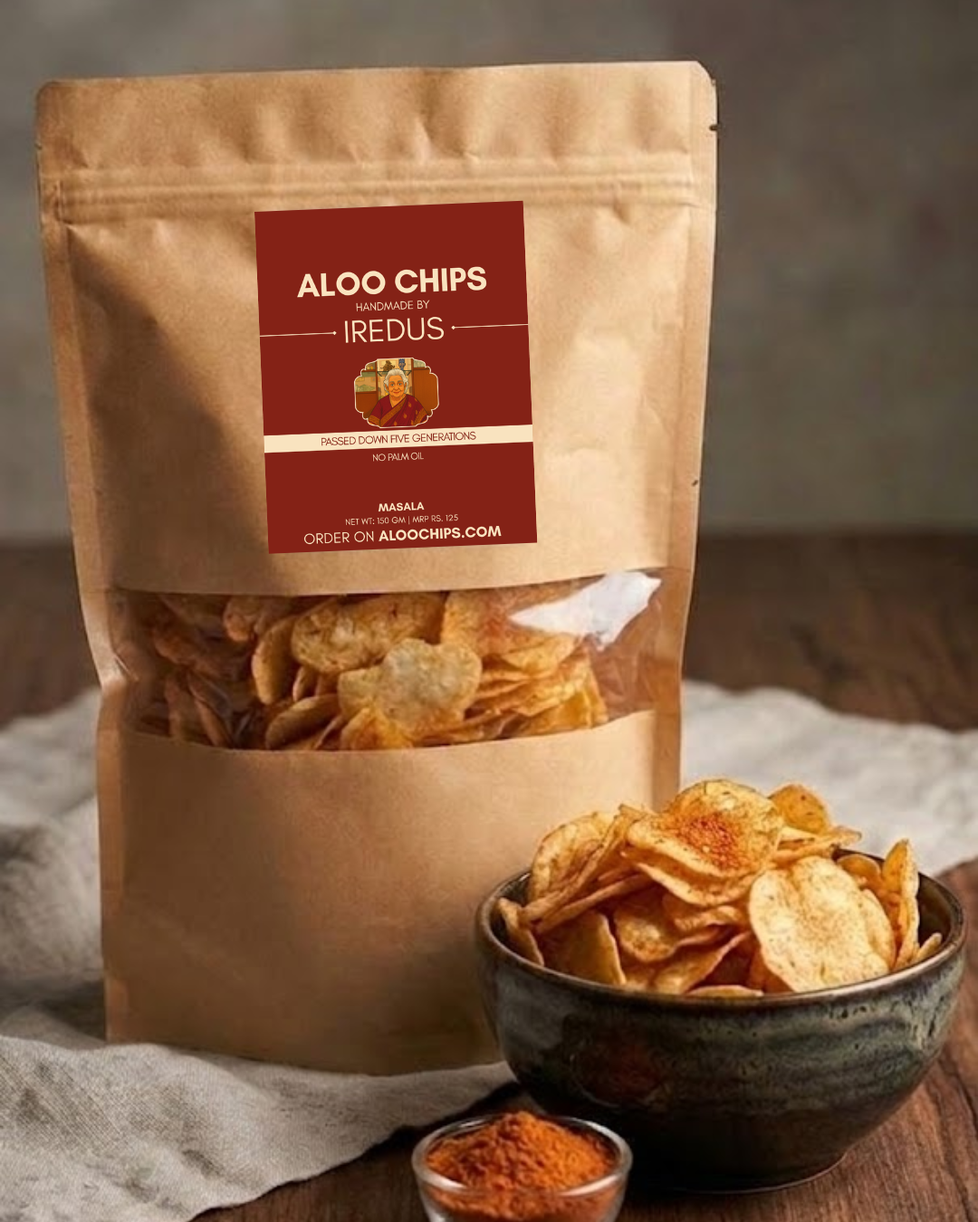 Brown paper bag of Aloo Chips with a bowl of chips and spices on a wooden surface.