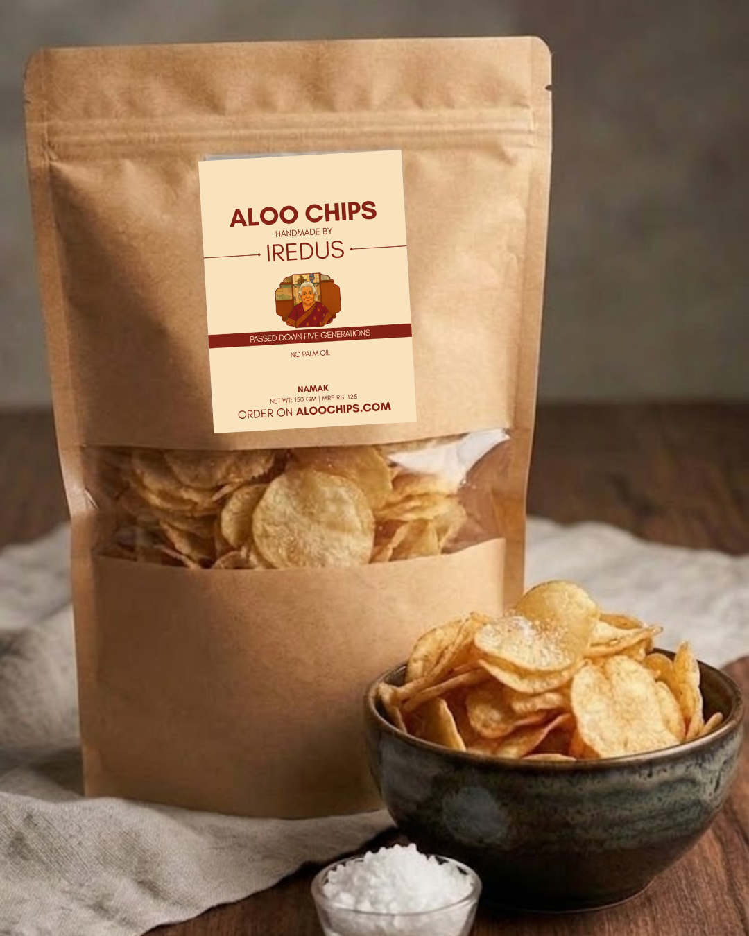 Kraft paper bag of Aloo Chips with a bowl of chips and salt on a wooden surface.